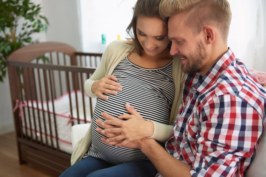 femme enceinte et futur papa dans la chambre du bébé